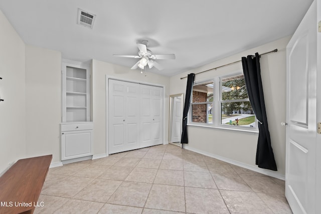 unfurnished bedroom with a closet, ceiling fan, and light tile patterned floors