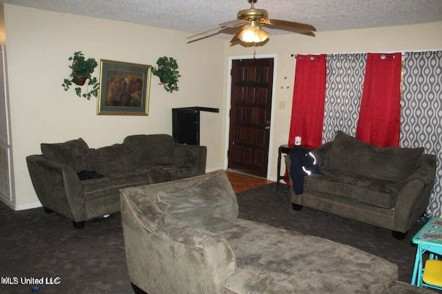 living room featuring ceiling fan and a textured ceiling