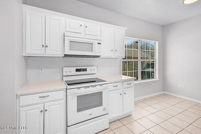 kitchen featuring white cabinets, light tile patterned flooring, and white appliances