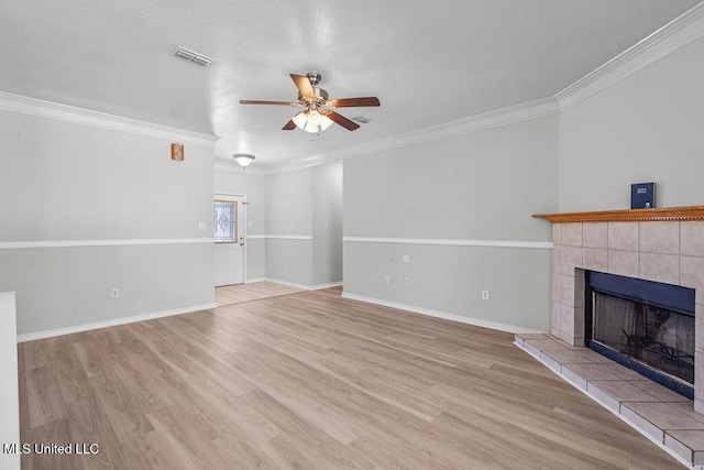 unfurnished living room with light hardwood / wood-style floors, ceiling fan, crown molding, and a tiled fireplace