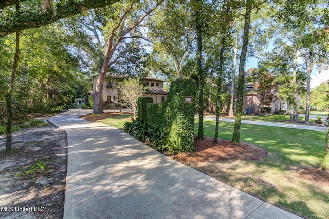 view of home's community with a lawn and concrete driveway