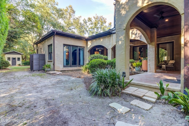 back of property with stucco siding and a patio