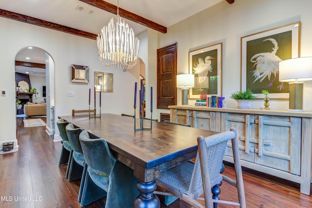 dining room with arched walkways, beamed ceiling, visible vents, and dark wood-style flooring