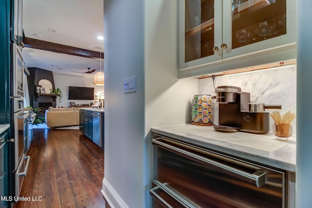 interior space with dark wood-style floors, baseboards, a fireplace, ceiling fan, and backsplash