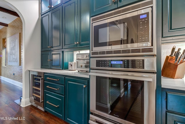 kitchen with stainless steel appliances, wine cooler, dark wood-type flooring, and light countertops