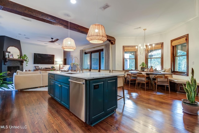 kitchen featuring dark wood finished floors, light countertops, stainless steel dishwasher, blue cabinets, and a sink