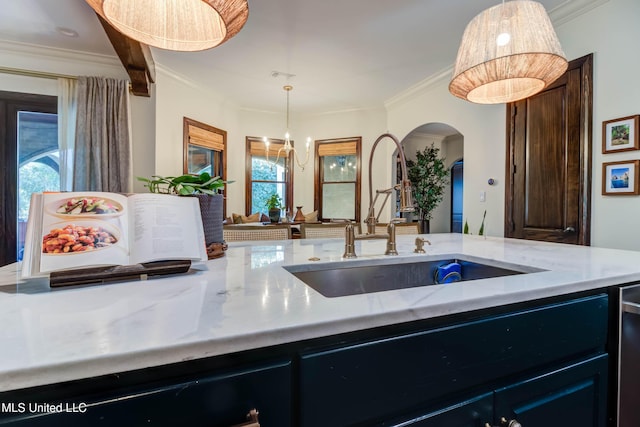 kitchen with visible vents, arched walkways, a sink, pendant lighting, and crown molding