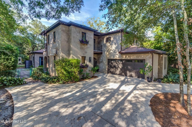 view of front facade with a garage, a balcony, driveway, and stucco siding