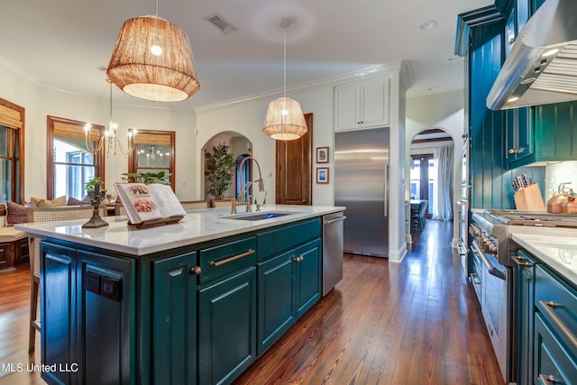 kitchen with high end appliances, visible vents, arched walkways, a sink, and under cabinet range hood