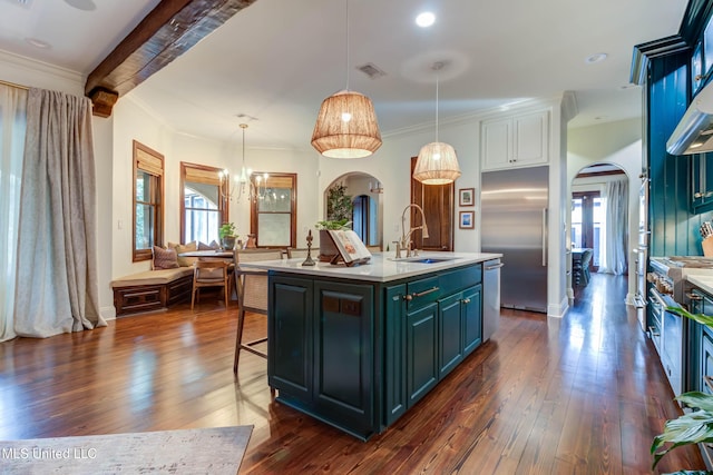 kitchen with visible vents, a kitchen bar, light countertops, arched walkways, and a sink