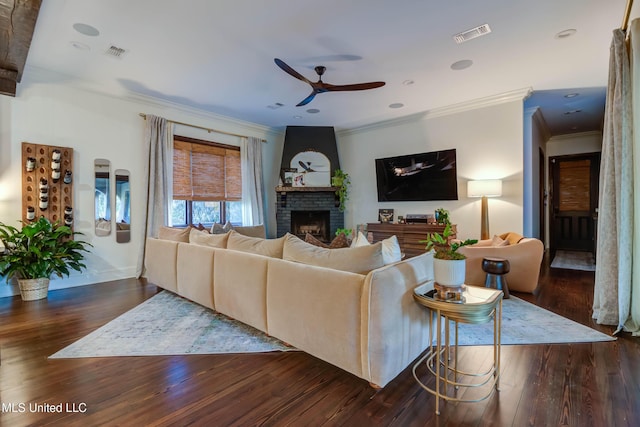 living area featuring visible vents, wood finished floors, a brick fireplace, and ceiling fan