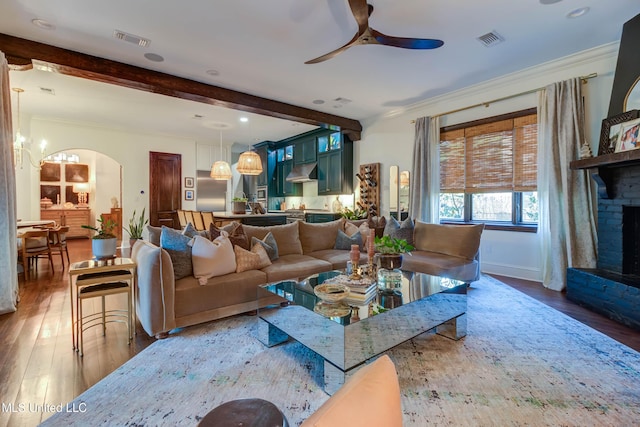 living room with arched walkways, visible vents, ceiling fan, and hardwood / wood-style floors