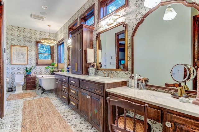 full bath featuring a chandelier, a soaking tub, wallpapered walls, and vanity