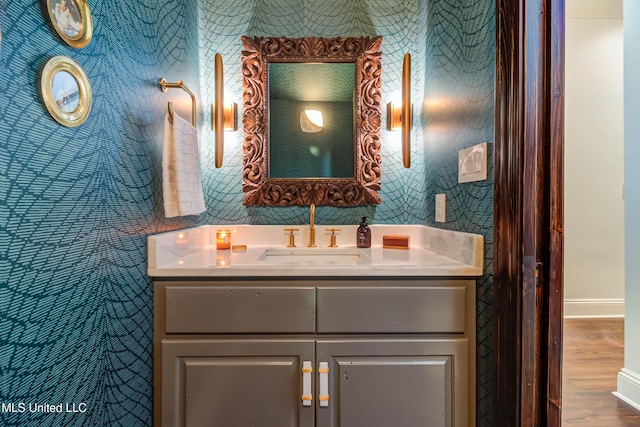 bathroom with baseboards, wood finished floors, and vanity