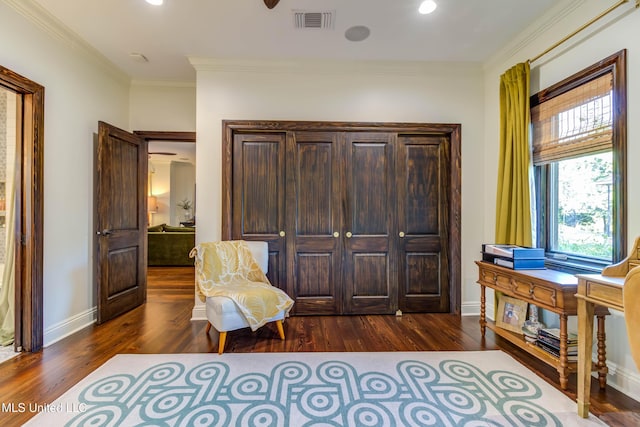 sitting room featuring baseboards, wood finished floors, visible vents, and ornamental molding