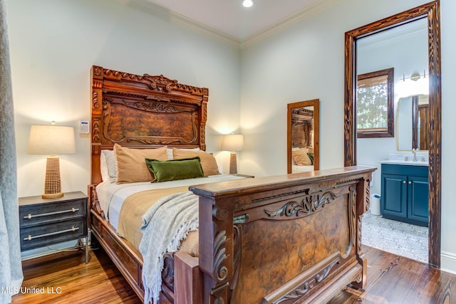 bedroom featuring connected bathroom, crown molding, recessed lighting, wood-type flooring, and a sink