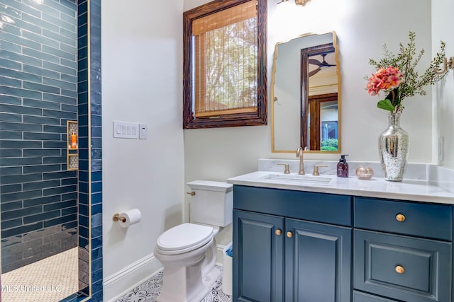 full bath featuring baseboards, tiled shower, toilet, and vanity