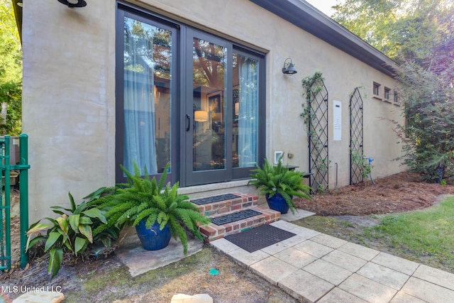 entrance to property with french doors and stucco siding