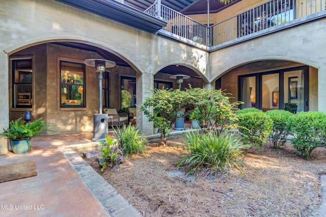 property entrance with covered porch and a balcony