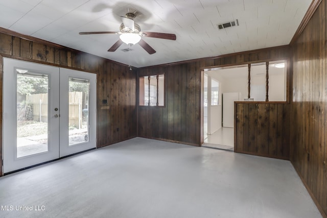 2610 Demaret Dr, Gulfport, MS 39507 - unfurnished room featuring french doors, wood walls, a ceiling fan, and concrete floors