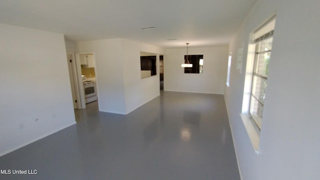 2610 Demaret Dr, Gulfport, MS 39507 - spare room featuring a chandelier, concrete floors, and baseboards