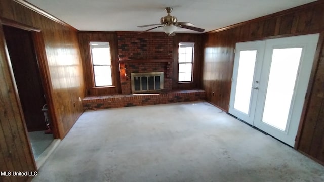 2610 Demaret Dr, Gulfport, MS 39507 - unfurnished living room featuring french doors, wood walls, ceiling fan, crown molding, and a brick fireplace