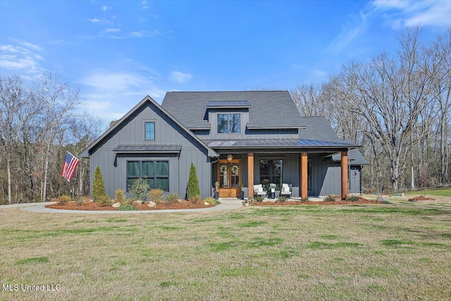 modern farmhouse style home with metal roof, a porch, board and batten siding, a standing seam roof, and a front yard