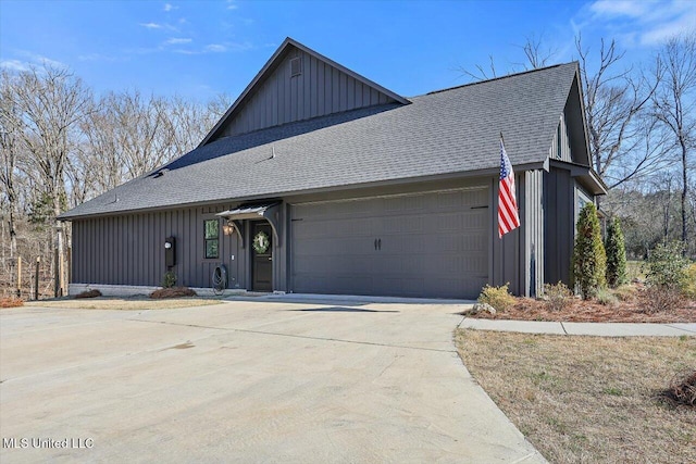 view of front of home with a garage, driveway, board and batten siding, and roof with shingles