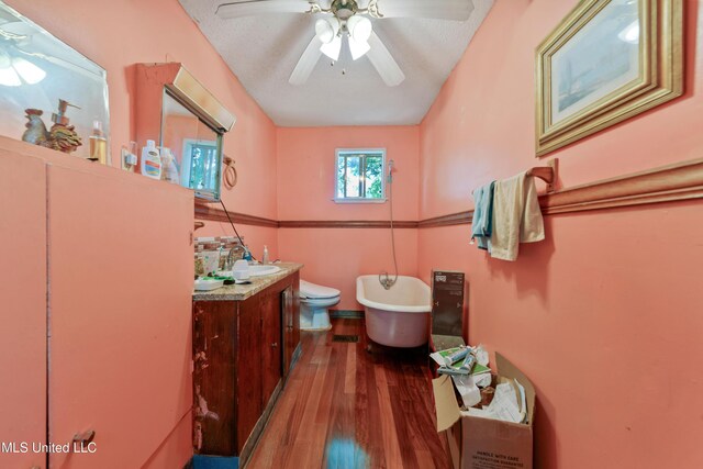 3902 Pascagoula St, Pascagoula, MS 39567 - bathroom with wood finished floors, vanity, a soaking tub, ceiling fan, and toilet