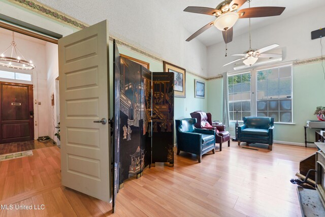 3902 Pascagoula St, Pascagoula, MS 39567 - sitting room featuring light wood-style floors, ceiling fan, a chandelier, and a towering ceiling