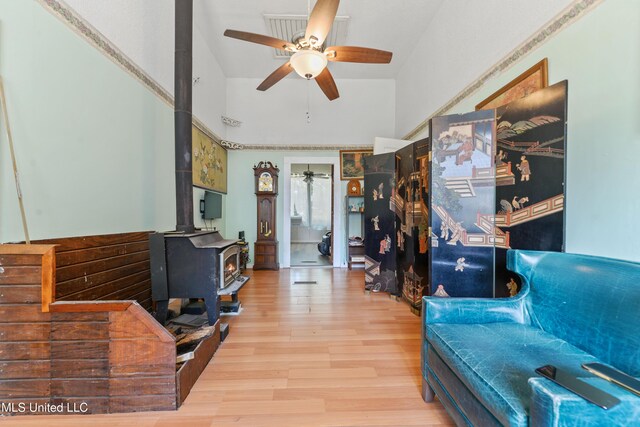 3902 Pascagoula St, Pascagoula, MS 39567 - living area with a ceiling fan, a wood stove, wood finished floors, and a towering ceiling