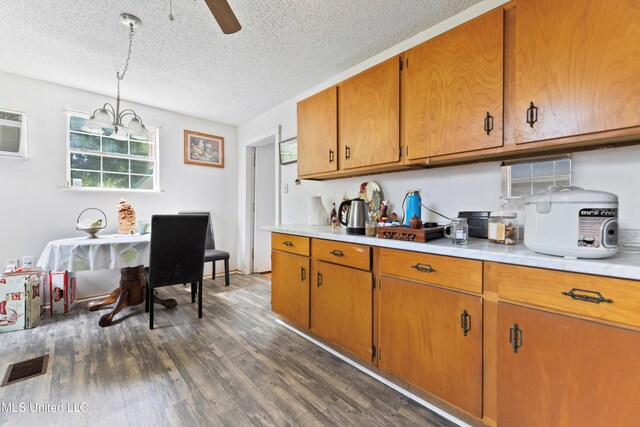 3902 Pascagoula St, Pascagoula, MS 39567 - kitchen with a textured ceiling, light countertops, dark wood-type flooring, brown cabinetry, and ceiling fan