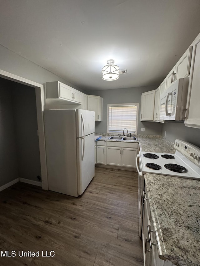 kitchen with white appliances, dark wood-style floors, visible vents, a sink, and white cabinetry