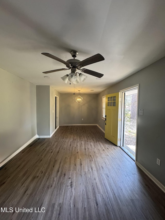 interior space with baseboards, wood finished floors, and a ceiling fan