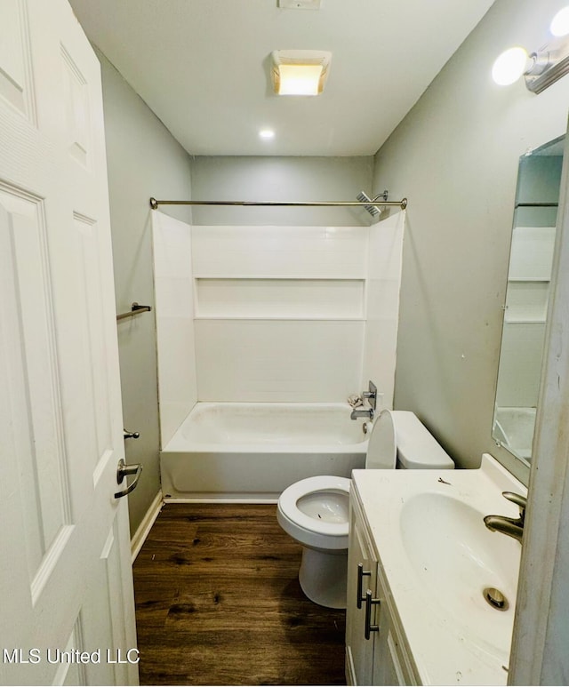 full bath with toilet, vanity,  shower combination, and wood finished floors