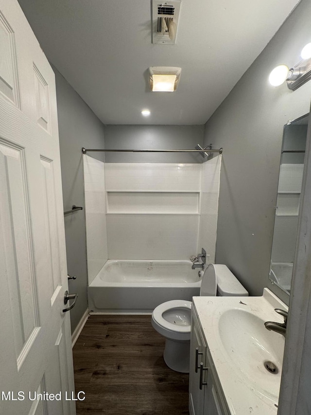 bathroom with vanity, wood finished floors, visible vents, bathtub / shower combination, and toilet