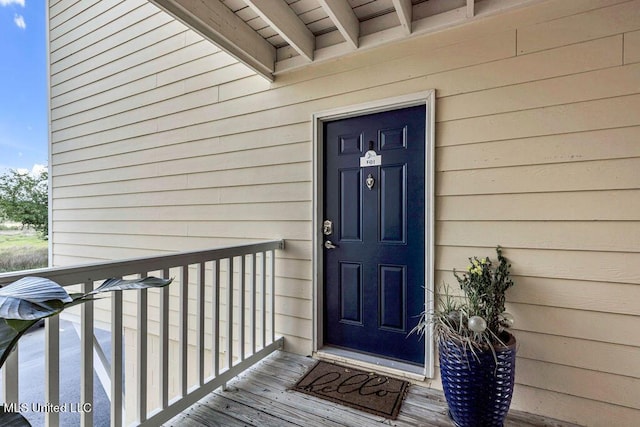 view of exterior entry with a balcony