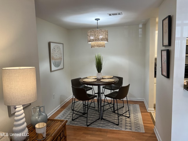 dining area featuring dark hardwood / wood-style flooring and a notable chandelier