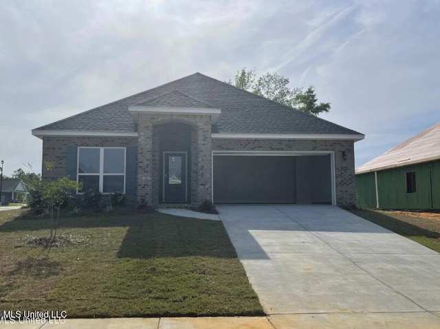 ranch-style house with driveway, a front lawn, roof with shingles, a garage, and brick siding