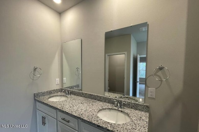 full bathroom with double vanity and a sink