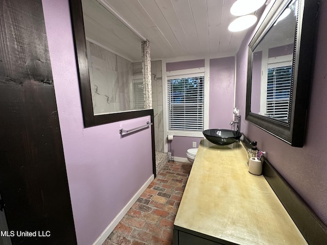 full bathroom featuring brick floor, toilet, wood ceiling, vanity, and baseboards