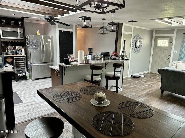 dining area with ceiling fan and light wood-style floors