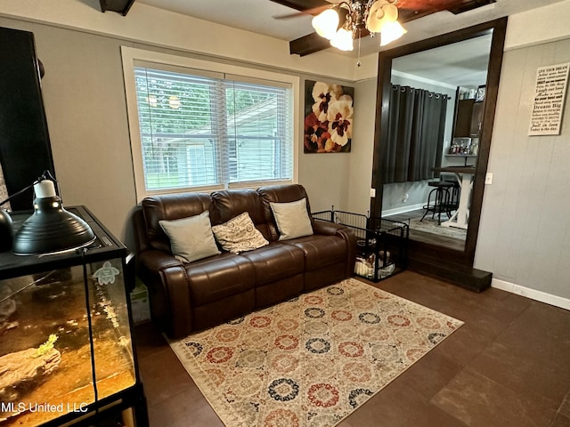 living area with baseboards and a ceiling fan