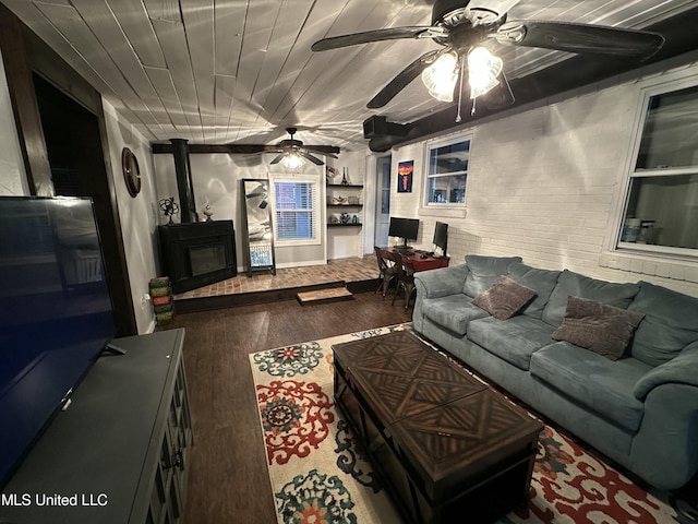 living area with brick wall, wood finished floors, wood ceiling, built in features, and a wood stove