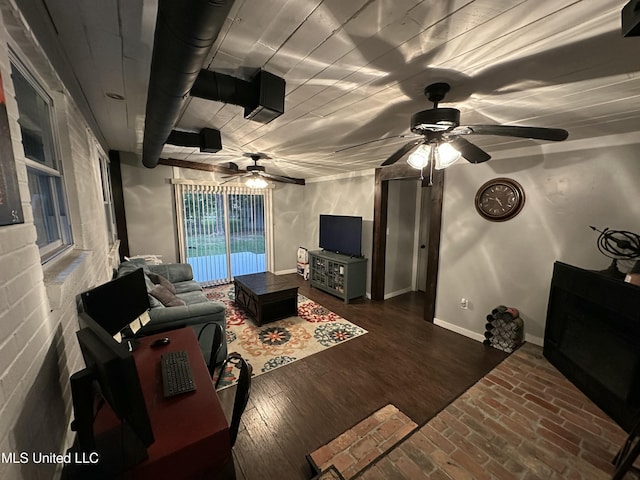 living room featuring brick floor, a ceiling fan, and baseboards