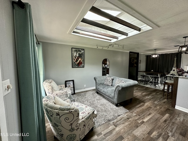 living area with a skylight, baseboards, and dark wood-type flooring