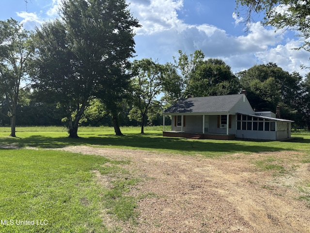 232 Renfroe Rd, Canton, MS 39046 - view of grassy yard with a sunroom, driveway, and covered porch