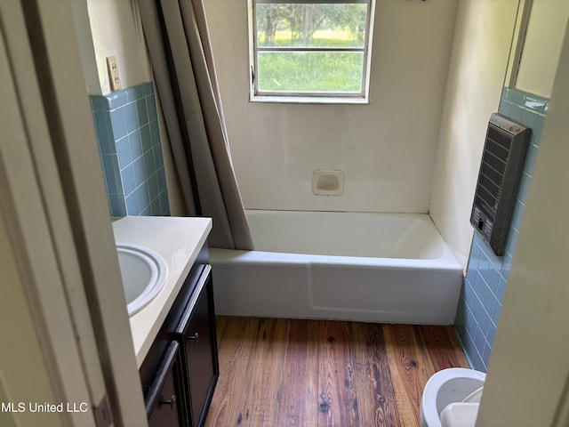 232 Renfroe Rd, Canton, MS 39046 - bathroom featuring tile walls, vanity, heating unit, wood finished floors, and shower / tub combo