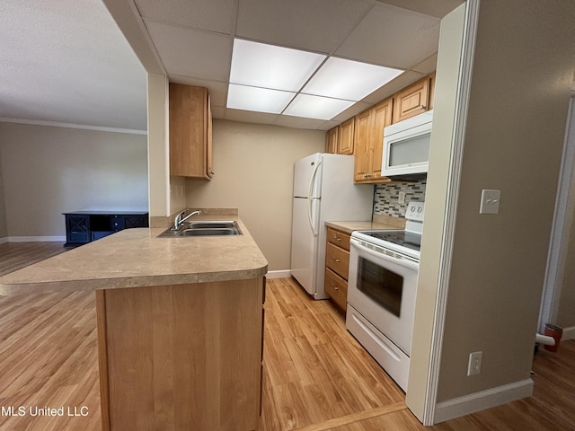 248 Lakeside Villa Unit J, Diamondhead, MS 39525 - kitchen with white appliances, light wood-style flooring, decorative backsplash, a sink, and baseboards