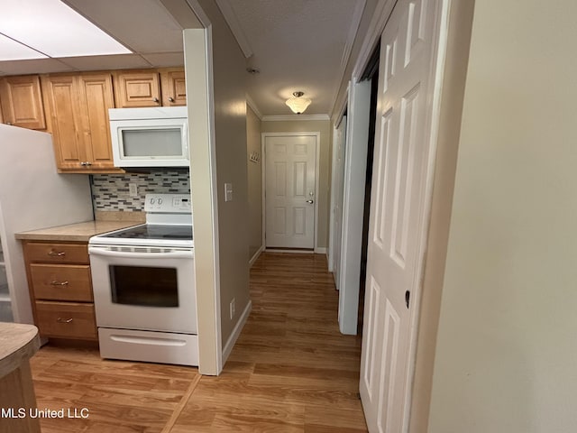 248 Lakeside Villa Unit J, Diamondhead, MS 39525 - kitchen featuring light wood-style floors, light countertops, ornamental molding, white appliances, and backsplash